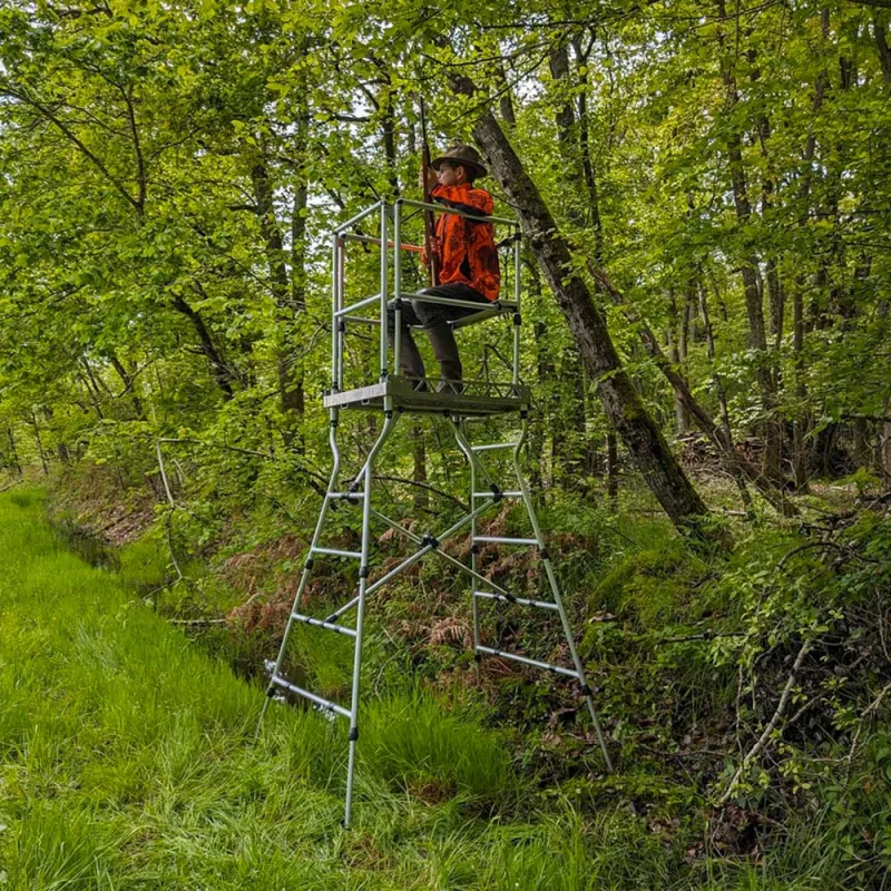 Mirador de battue pliable en aluminium installé en milieu boisé